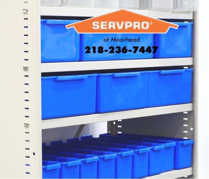 Plastic bins are stored on shelves.