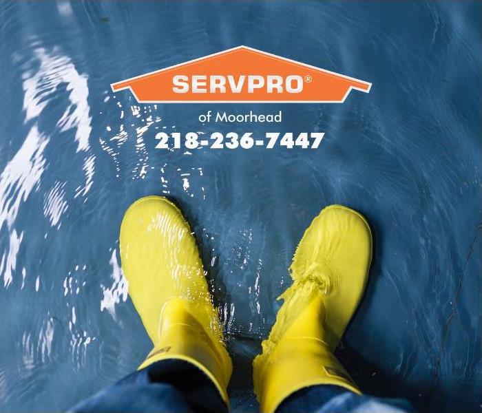 A person is shown standing in water inside a structure wearing yellow rubber boots.