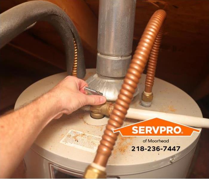 The temperature and pressure valve are adjusted on a water heater.