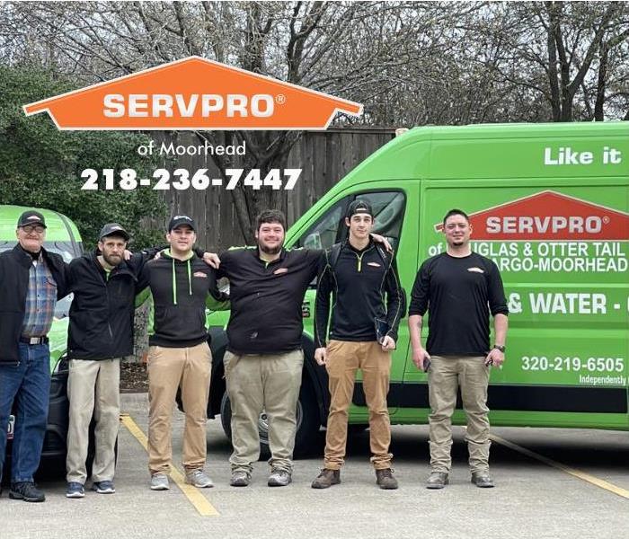 A team of SERVPRO of Moorhead technicians are standing in front of their vehicles, ready to travel to Texas to help out with 