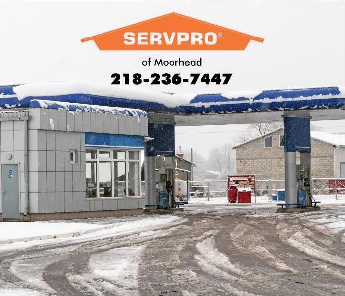 A gas station is shown on a cold snowy winter day.