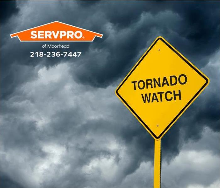 A tornado watch sign and a stormy sky in the background are shown.